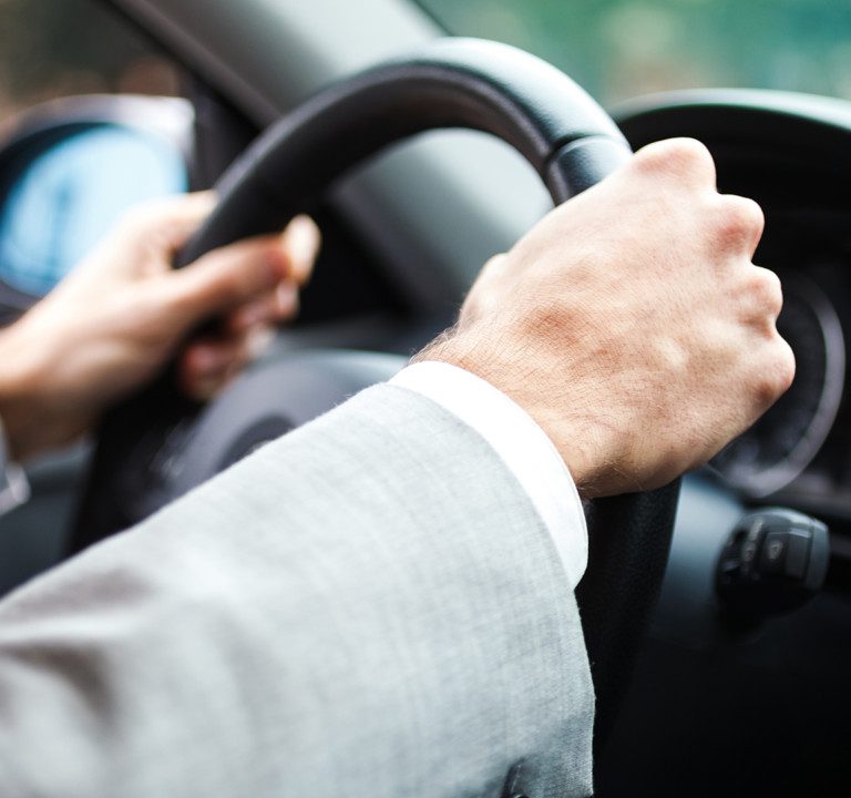 Person in business attire driving car.