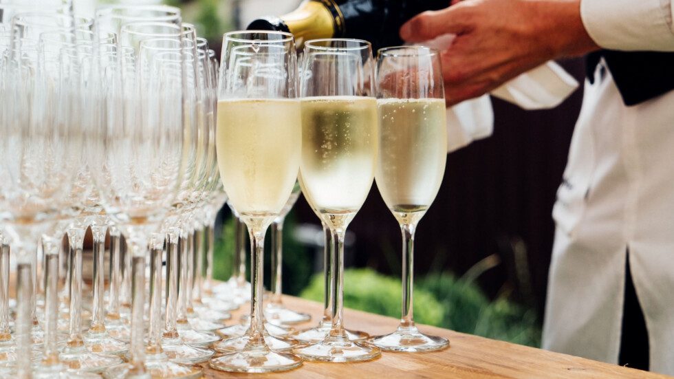 Waiter pouring champagne into glasses
